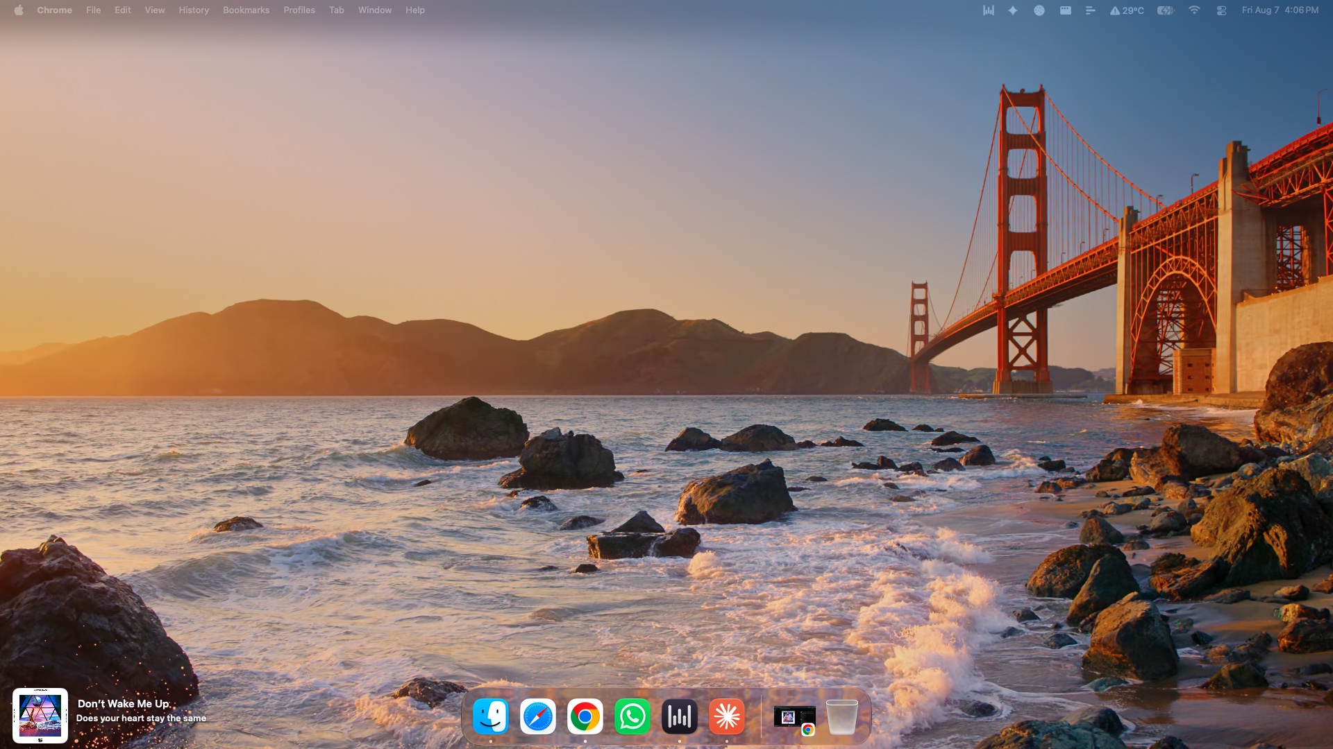 A full macOS desktop at sunset. The Now widget sits in the bottom-left corner beside the Dock, showing album art, the track title 'Don't Wake Me Up', and the lyric line playing at that moment. Now itself has no icon in the Dock.